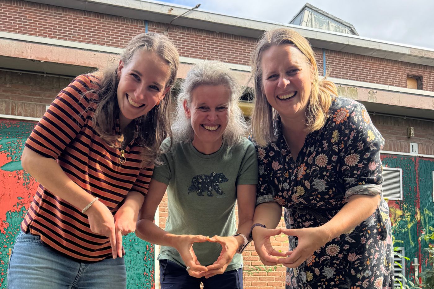 Patricia, Peggy en Janneke vormen samen een hart met hun handen